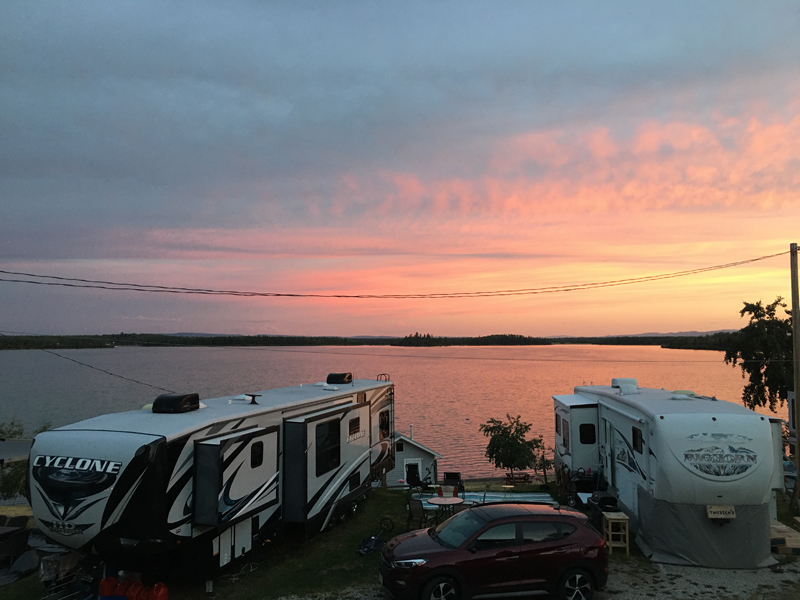 Pink sunset over RV trailers by the beach.